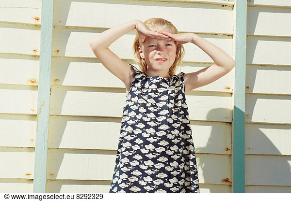 Child covering her eyes from sun glare