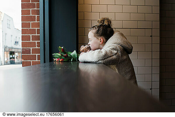 child in a cafe enjoying a pastry on her own