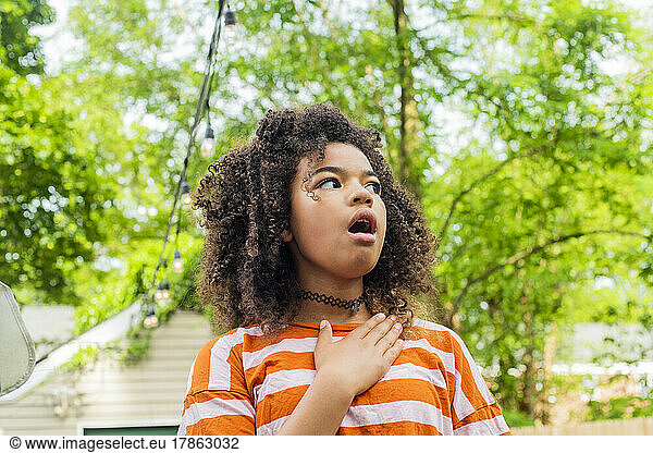 Child in backyard acting surprised