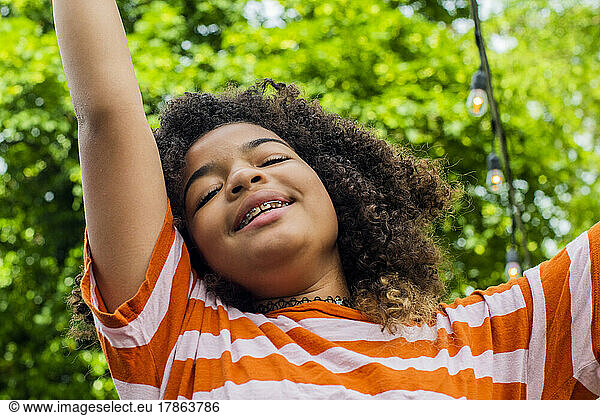 Child in backyard jumping for joy