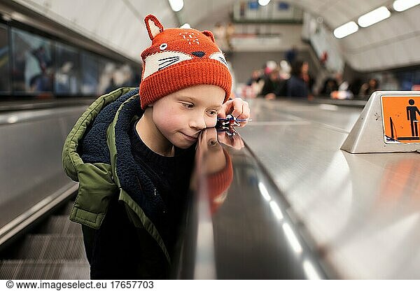 child playing on an escalator in an underground London station