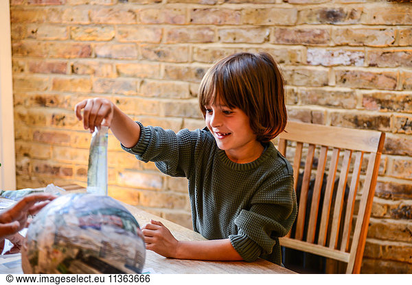 Child playing with papier mache