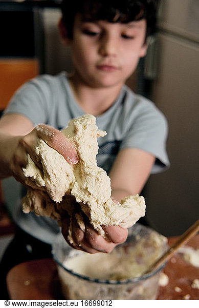 child preparing pizza dough to make at home