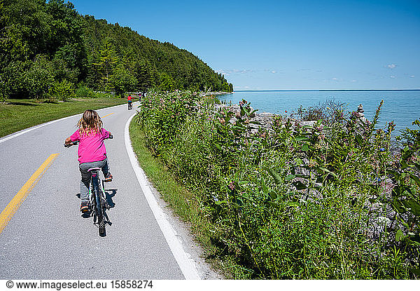 Child riding bicycle on Lake Shore Road on Mackinac Island