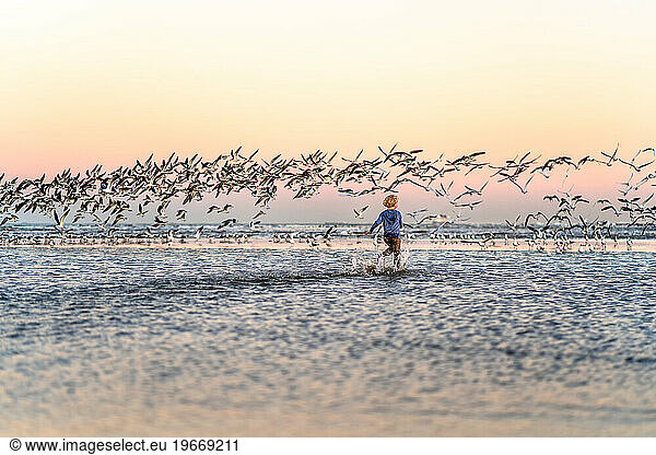 Child running through water at dusk