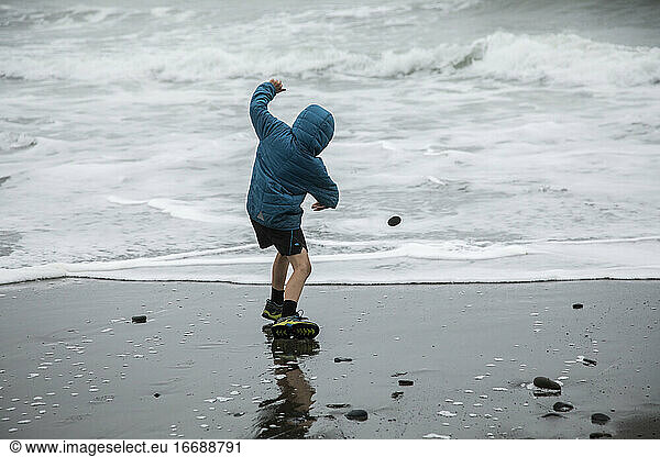 Child Skipping Rocks on Pacific Ocean