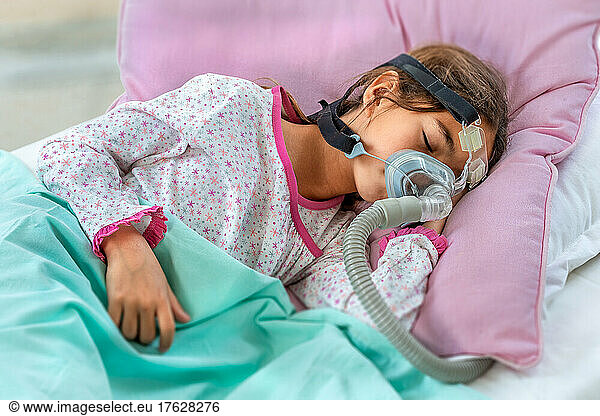 Child suffering from Sleep Apnea  using a CPAP machine