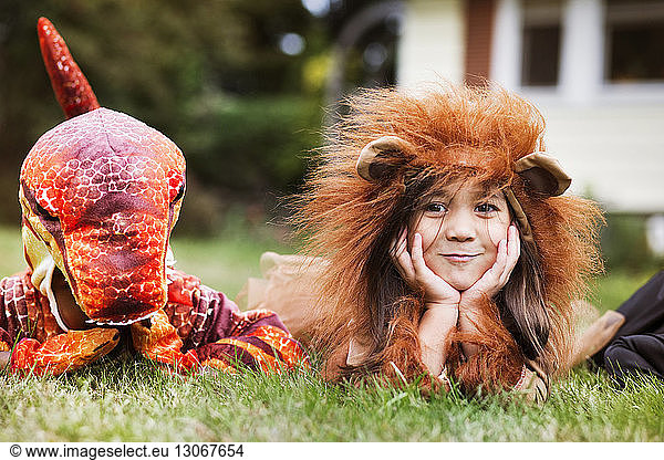 Children in costumes lying on grass during Halloween