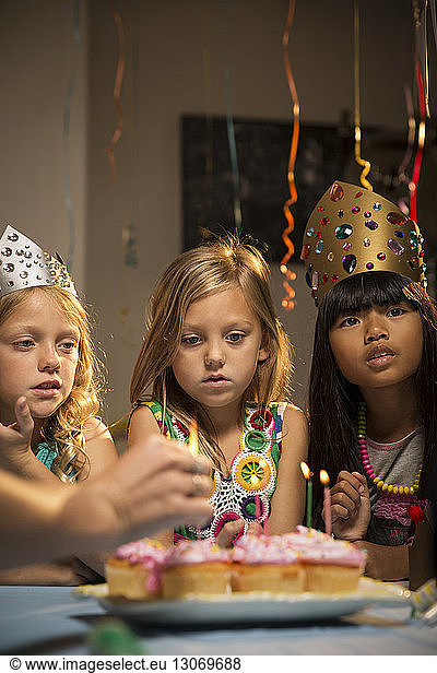 Children looking at cup cakes during birthday party