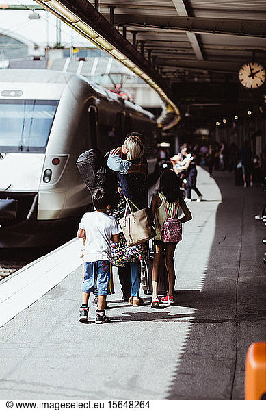 Children looking at parents embracing on train station