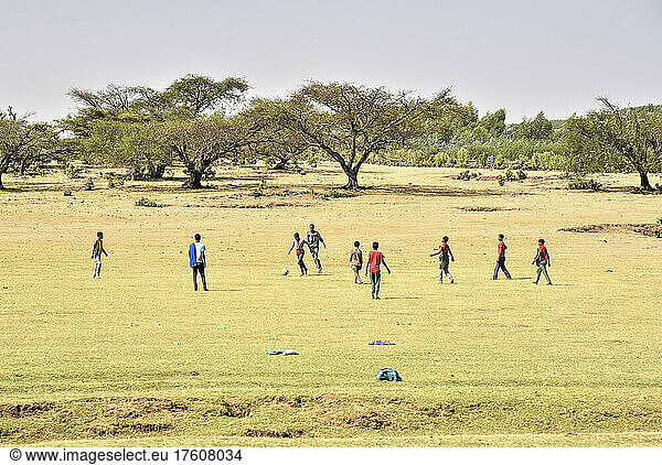 Children playing soccer on a grass field in rural Ethiopia; Ethiopia
