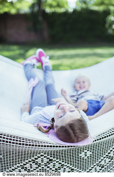 Children relaxing in hammock outdoors