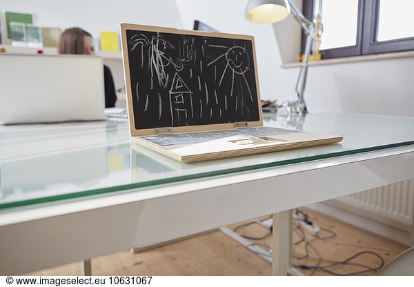 Children's toy notebook with chalk drawing on a desk