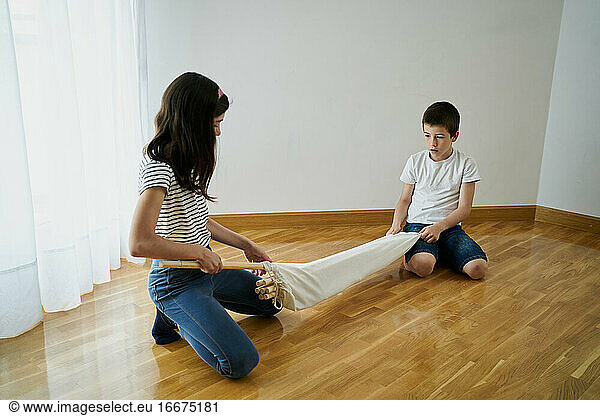 Children setting up a teepee tent inside their house. Childhood concept