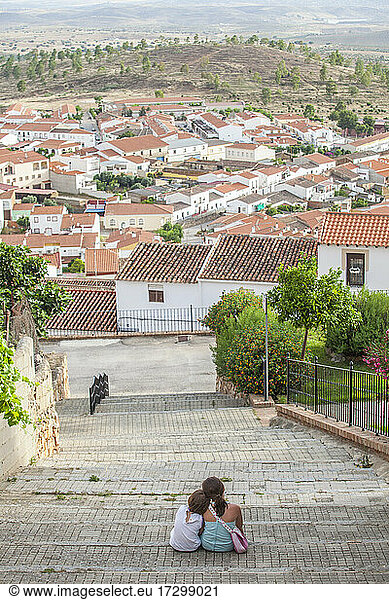 Children sitting on stairs of steep street in Hornachos  Spain