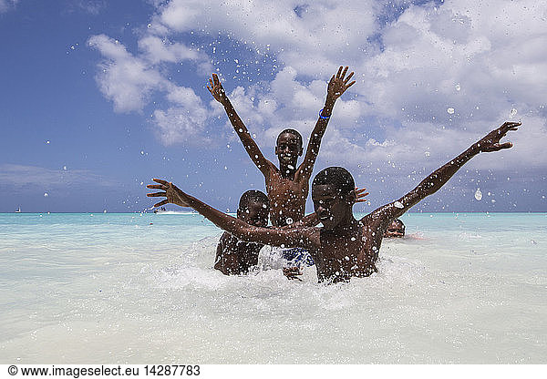 Children smile in the turquoise waters of Caribbean Sea The Nest  Antigua and Barbuda  Leeward Islands  West Indies