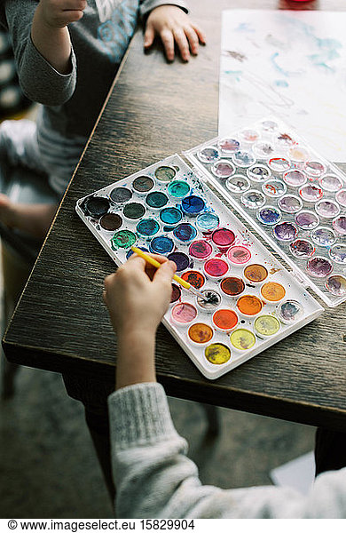 Children spending an afternoon painting with watercolors.