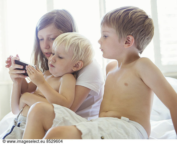 Children using cell phone together