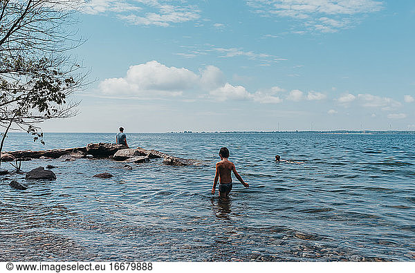 Children wading and swimming in Lake Ontario on a hot summer day.