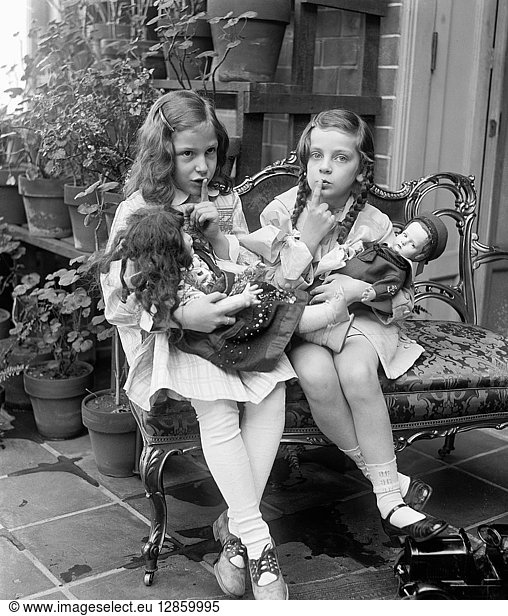 CHILDREN WITH DOLLS  c1920. Two girls playing with dolls. Photograph  c1920.