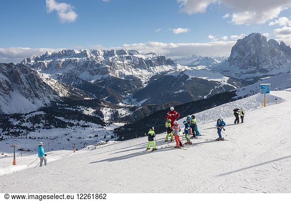 Children with ski instructor on the ski slope  Seceda ski area  in the back Sella massif  Sankt Cristina in Val Gardena  Dolomites  South Tyrol  Alto Adige  Italy  Europe