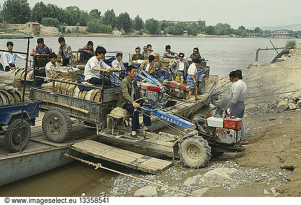 CHINA Yellow River Men taking a tractor off a ferry