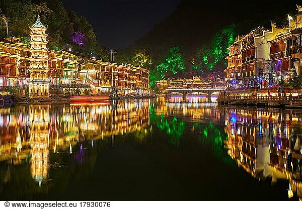 Chinesische Touristenattraktion  Feng Huang Ancient Town (Phoenix Ancient Town) am Tuo Jiang River mit der nachts beleuchteten Wanming-Pagode. Provinz Hunan  China  Asien