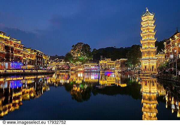 Chinesische Touristenattraktion  Feng Huang Ancient Town (Phoenix Ancient Town) am Tuo Jiang River mit der nachts beleuchteten Wanming-Pagode. Provinz Hunan  China  Asien
