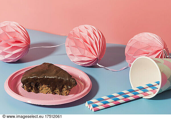 Chocolate cake  tissue paper pom-poms and paper cups and straws