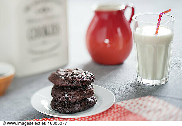 Chocolate cookies with dried sour cherries and glass of milk