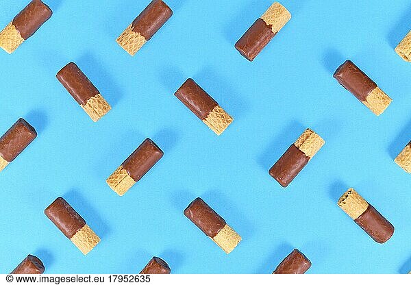 Chocolate glazed waver rolls sweets arranged on blue background