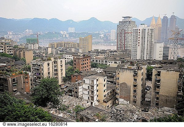 Chongqing  China  Asien - Überblick über das Stadtbild mit Abbruchhäusern im Zentrum der chinesischen Metropole und dem Jangtse-Fluss im Hintergrund. Die Megastadt liegt am Zusammenfluss von zwei großen Wasserstraßen  dem Jangtse und dem Jialing-Fluss  und ist eine der am schnellsten wachsenden Metropolen der Welt.
