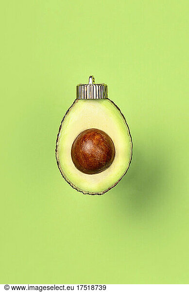 Christmas bauble decoration of avocado on green. New year concept.