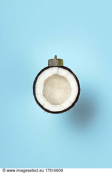 Christmas bauble decoration of coconut on blue. New year concept.