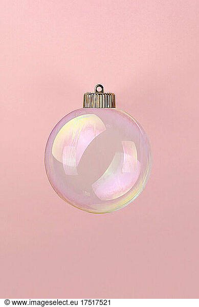 Christmas bauble decoration of soap bubble on pink. New year concept.
