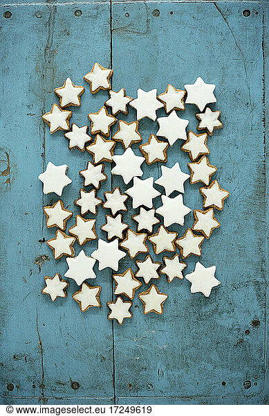 Christmas cinnamon star shaped cookies on blue rustic wooden background