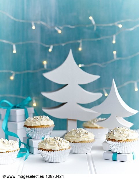 Christmas cupcakes decorated with silver cake decorations in festive setting