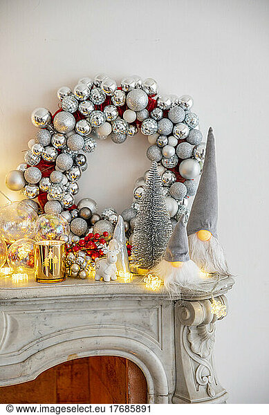 Christmas decoration with illuminated lights on marble fireplace