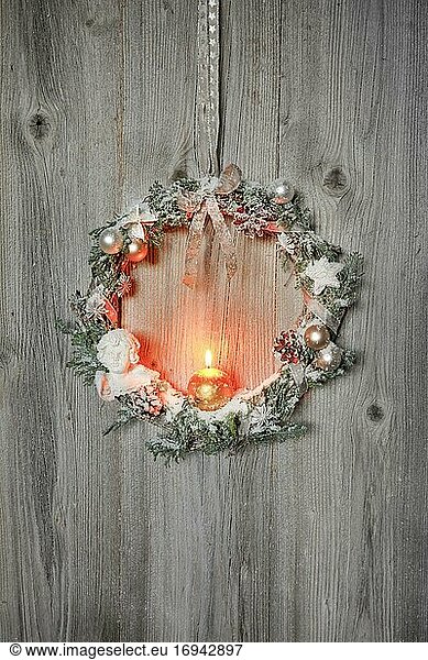 Christmas wreath on wooden wall with candle