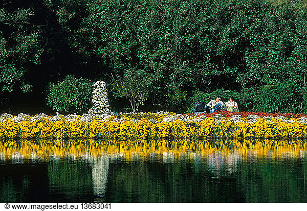 Chrysanthemums and visitors along Mirror Lake in Bellingrath Gardens  Alabama  in November.