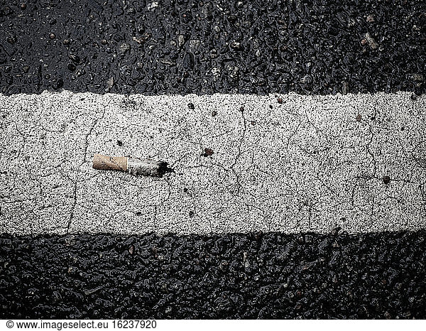 Cigarette but on road marking