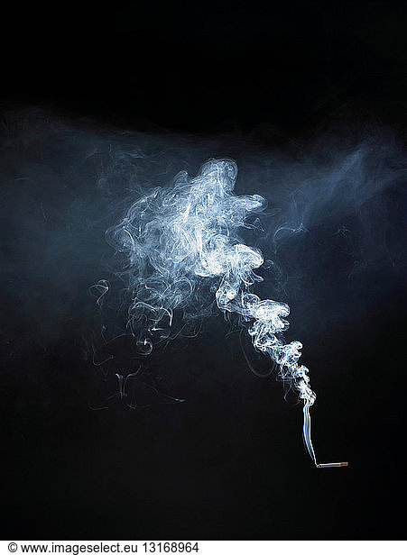 Cigarette with smoke on black background