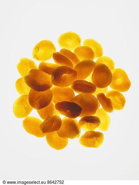 Circular pile of organic apricots on white background