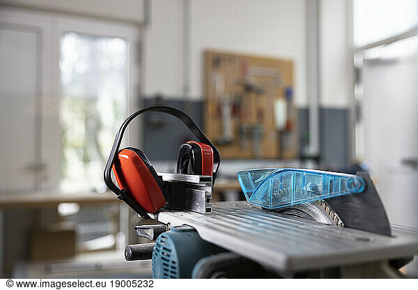 Circular saw and ear protectors in workshop