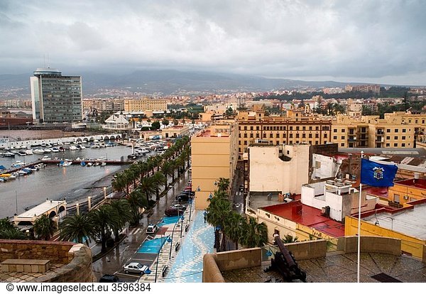 City and seaport seen from the old town with cannon and flag of Melilla Melilla Spain Europe