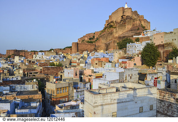 Cityscape of Jodhpur with traditional indigo blue and white painted houses and the 15th century Mehrangarh Fortress on the hilltop.