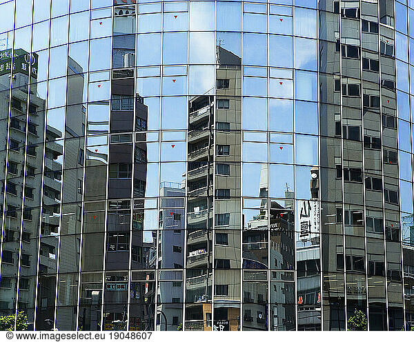 Cityscape reflected in glass windows  Tokyo  Japan.