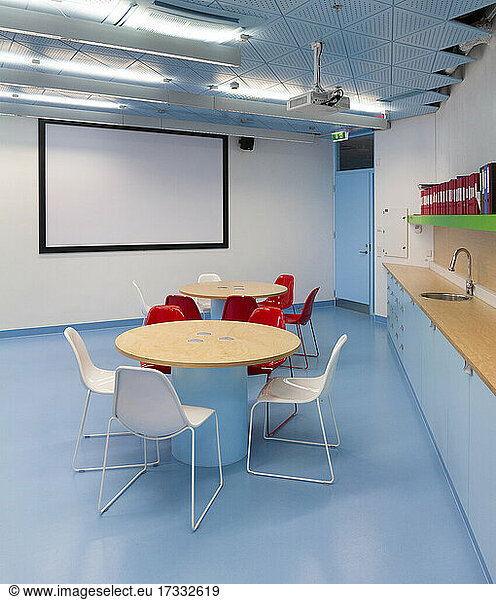 Classroom with white board  round tables and counter and sink