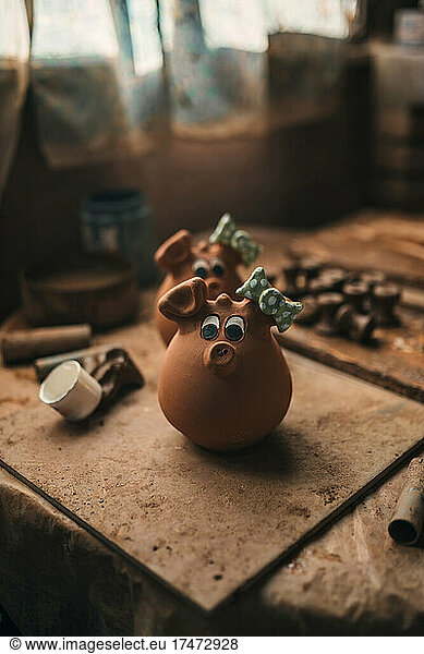 Clay decoration with pig face on table in pottery
