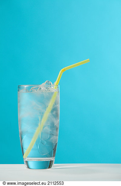Clear glass of water with yellow drinking straw